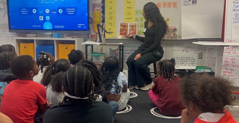 Student reading to an elementary class